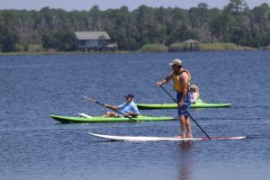 people on kayaks and stand up paddle boards