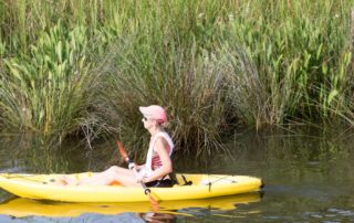 A person in a yellow kayak Description automatically generated with low confidence